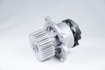 New metal automobile pump for cooling an engine water pump on a gray background with a gradient. The concept of new spare parts for the car engine