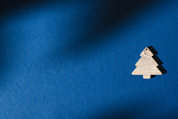 Creative greeting card for New Year or Christmas. Wooden Christmas tree on a purple background with shadows. Copy space. Flat lay