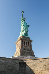 Fototapeta na wymiar Statue of Liberty with pedestal from bottom to top on a clear blue sky day, New York, USA. The Statue of Liberty Enlightening the World.