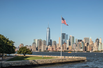 Panorama of New York with Liberty Island in the foreground with a American Flag waving in the wind...