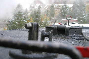 Steam locomotive details on a rainy, snowy day