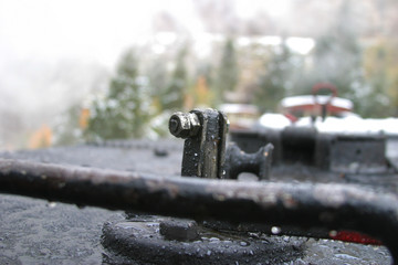Steam locomotive details on a rainy, snowy day