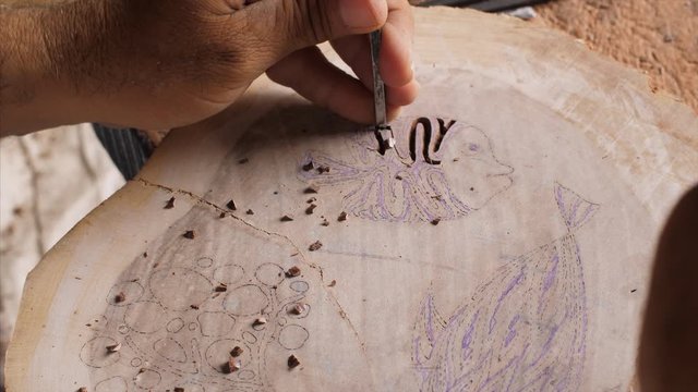 Block Printing - Indian artisanal carver creating a wood block stamp. 