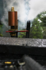 Steam locomotive details on a rainy, snowy day