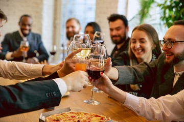 Happy co-workers celebrating while company party and corporate event. Young caucasian people in...