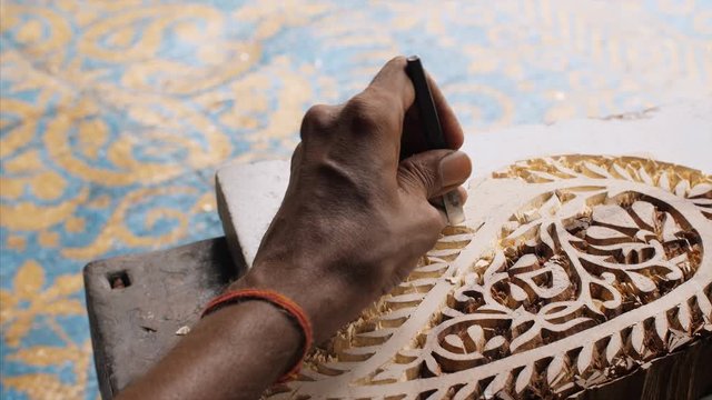 Block Printing - A craftsman is creating a beautiful design for printing block stamp . 
