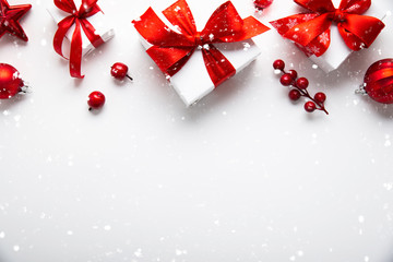 Christmas and New Year holiday background. Xmas greeting card. Christmas red ribbon gifts and ornaments on white background top view