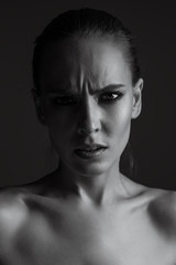Black-white portrait of a girl close-up. Female emotions of disgust and discontent on her face.
