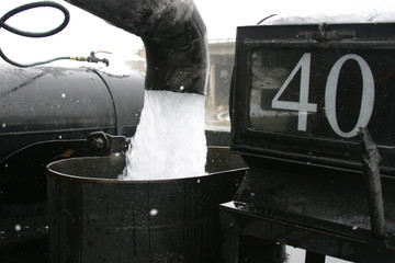 Steam locomotive details on a rainy, snowy day