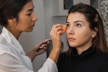 Make-up artist work, applying model makeup in the studio, close-up