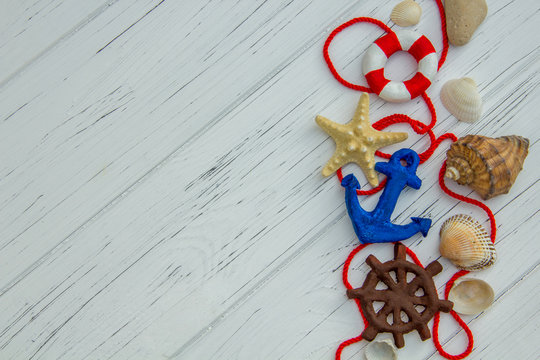 marine decor. starfish lifebuoy steering wheel anchor sea shells on white wooden background