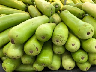 Pile of long green gourds at a fresh market section