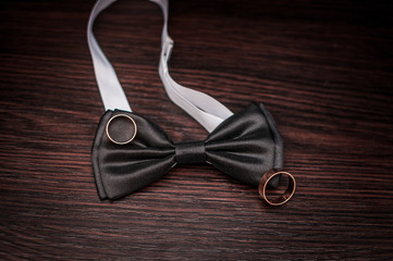 Pair of gold wedding rings and neck tie on the table