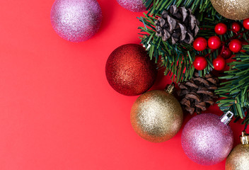 Christmas Decorations on red background, Christmas border with cedar leaf, pine cones and baubles.