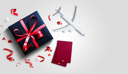Christmas travel planning. Traveling as gift. White blank model of passenger plane and gift box on...