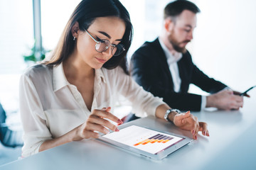 Businesswoman analyzing charts near man