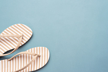 Flip flops shoes on blue flat lay background with copy space.
