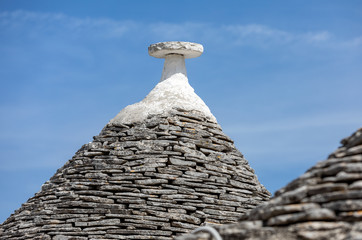 Fototapeta na wymiar Stone roofs of Trulli Houses in Alberobello; Italy. The style of construction is specific to the Murge area of the Italian region of Apulia (in Italian Puglia). Made of limestone and keystone.