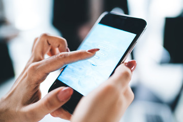 Crop hands using smartphone in office