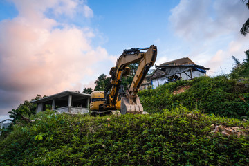 The modern excavator on the construction site with sunset sky. Large tracked excavator standing on...