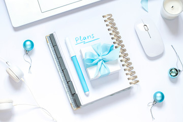 Christmas business flat lay with festive decorations, a gift and a keyboard on the white background. Making a plan for New Year concept top view. 