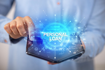 Businessman holding a foldable smartphone with PERSONAL LOAN inscription, new business concept