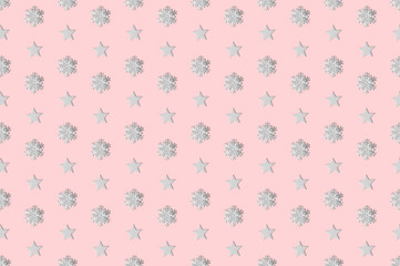 Flat lay winter pattern made of snowflakes and stars on rose background.