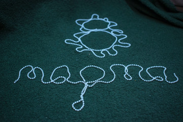 Eight and the word Mart Russian letters of white beads on a green background. As an example day card, happy woman. The symbol of 8 March