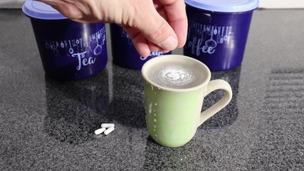 white pills in a capsule broken and poured into a cup