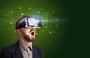 Businessman looking through Virtual Reality glasses with SOCIAL GAME inscription, social networking concept