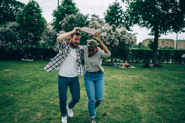 Diverse couple hiding from rain in park