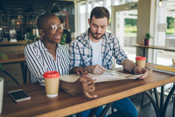 Multiracial couple organizing next travel on map