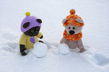 knitted cubs. Bears are sculpting a snowman. knitted bears in the snow
