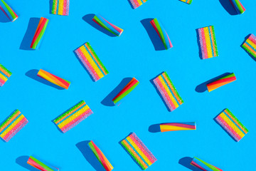 Pattern with colorful sweets on a blue background, top view flat lay