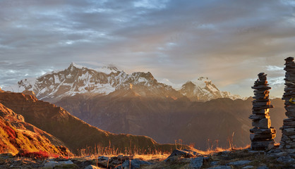 Sunrise overlooking the majestic Himalayan peaks - Annapurna IV and Annapurna II, covered with clouds illuminated by the sunrise. Long exposure.
