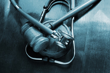 Wooden gavel and stethoscope on wooden table, malpractice concept