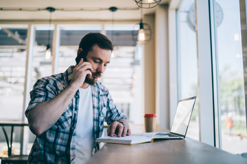 Freelancer talking to colleague on phone in cafeteria