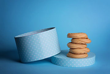 Fototapeta na wymiar Blue and white polka dot round gift box with round cookies beside.