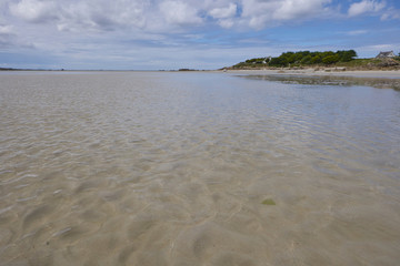 Low tide beach at the coast of Brittany, view from the sea to the land, summer feeling