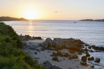 Coast in Brittany, shimmering water with a small boat, evening mood