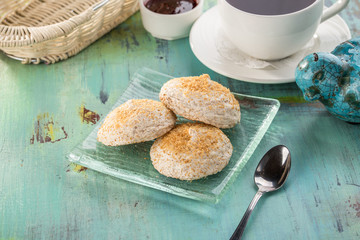almond and meringue biscuits and cup of black tea on blue wooden table