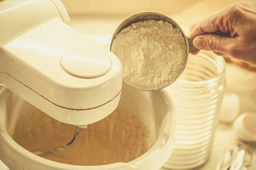 Baking concept - batter in mixer and ingredients, toned