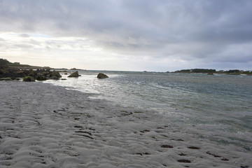 Silent peaceful beach at ebb during dusk, view to a small island