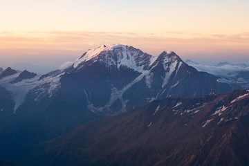 beautiful sunrise in the mountains. Golden hour photography, the rising sun behind the mountains. Yellow and pink color. Mount Elbrus. Russia. The Caucasus. Panorama of mountains at sunrise.