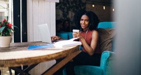 Smiling black woman surfing on laptop
