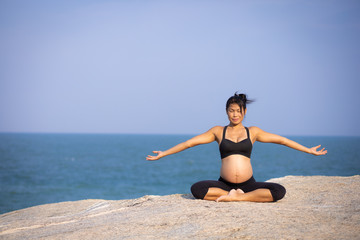Fototapeta na wymiar pregnant woman yoga pose on the beach sunset