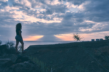Obraz premium silhouette of girl watching the sunset from the top of a ravine in Tenerife