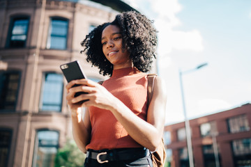 Focused female messaging on cellphone in street
