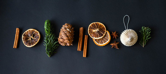 Christmas composition banner of various food ingredients and Christmas decor on a black background.