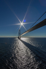 Oresund bridge with blue sky, blue sea, sun and flares